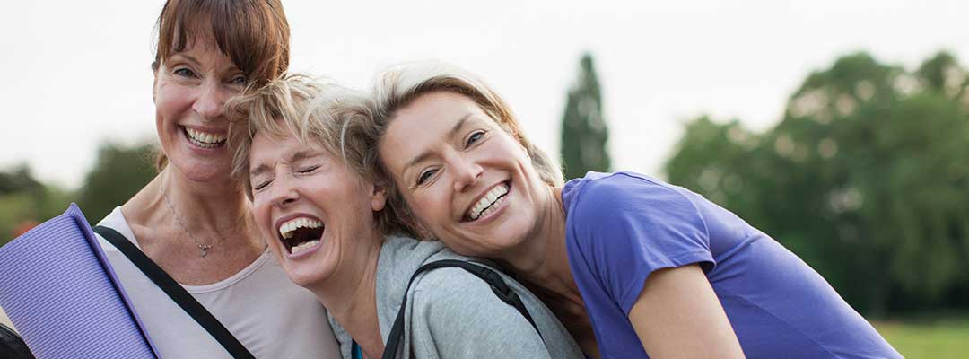 Three middle aged women laugh and embrace - this is a promotional photo used for Urolon treatment for leaky bladder and stress incontinence.