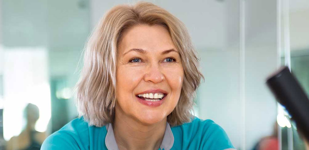 A promotional image for Urolon Stress Urinary Incontinencetreatment. It shows a happy elderly woman in a country lane. She is wearing headphones and seems to be out for a run.