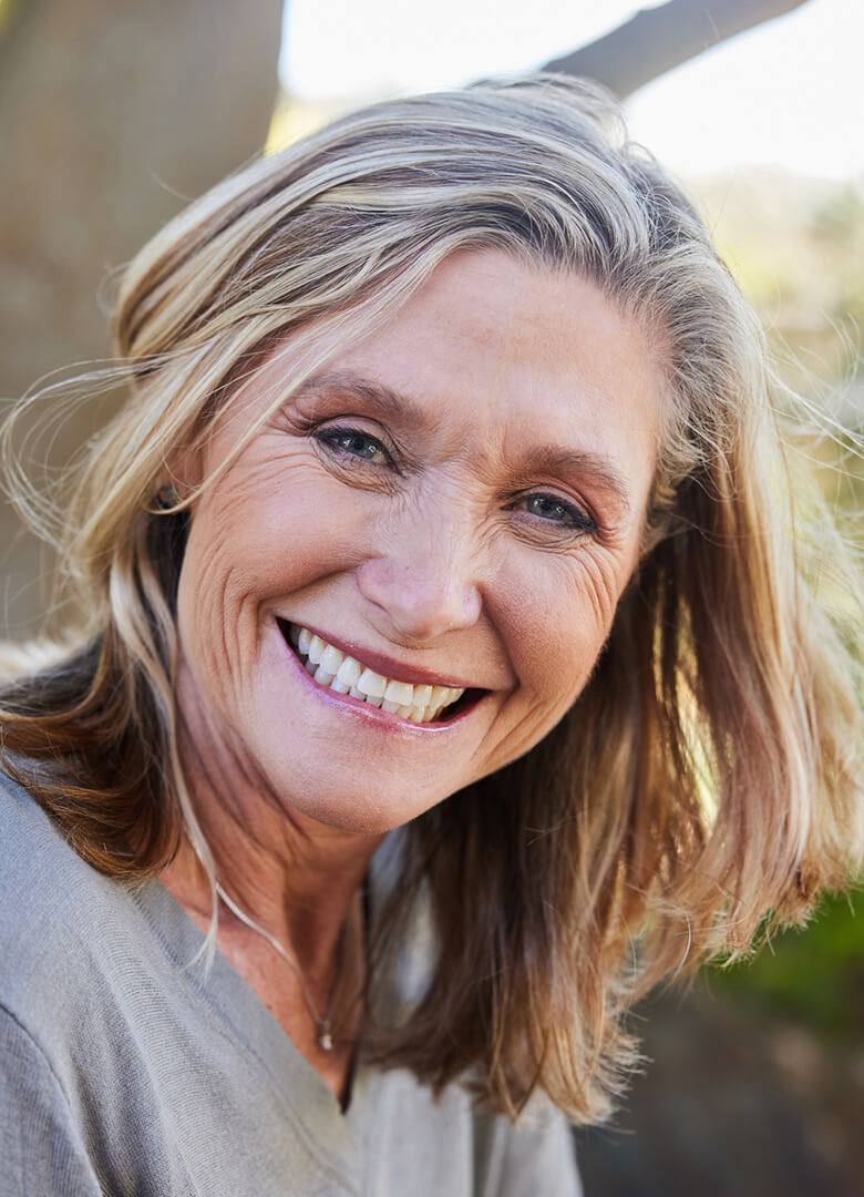 Vaginoplasty-image-B-780x1080-v01 A middle aged woman smiling at the camera